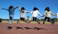 Vier Mädchen springen in die Luft