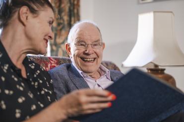 Älterer Mann und Frau schauen ein Buch an