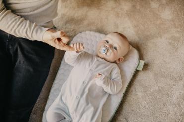 Baby hält die Hand einer Erwachsenen