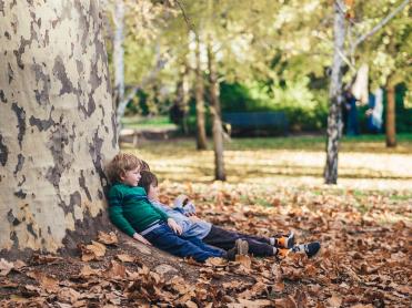 Kinder rasten sich unter einem Baum aus