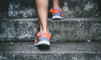 Person in sneakers climbs a staircase